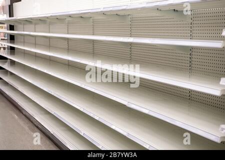 Empty Grocery Store Shelves in a grocery store due to the COVID-19 pandemic and buyers hoarding groceries Stock Photo