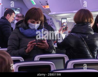 Passengers wearing protective masks due to COVID-19 coronavirus threat captured using their mobile phones inside an economy class cabin of Aeroflot's newest Airbus A350 jetliner.