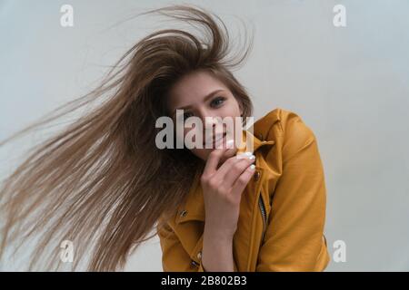 Young fair-skinned girl with long flying hair posing in the studio. wide angle lens and look at the camera. Stock Photo