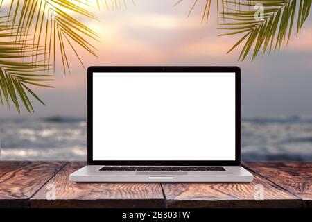 Laptop mockup screen on wooden table against sea background. Stock Photo