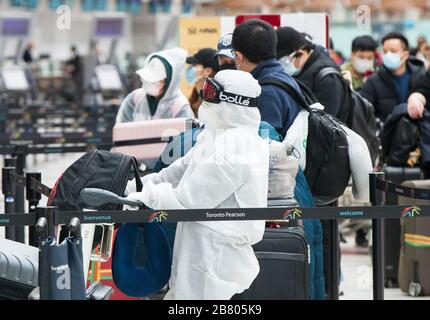 Toronto, Canada. 18th Mar, 2020. Travellers line up to check in at Terminal 3 of Pearson International Airport in Toronto, Canada, March 18, 2020. Canadian Prime Minister Justin Trudeau announced that the Canada-U.S. border will close to all non-essential travel, but shipments, trade and commerce will not be affected by the new restriction at the Canada-U.S. border. Credit: Zou Zheng/Xinhua/Alamy Live News Stock Photo