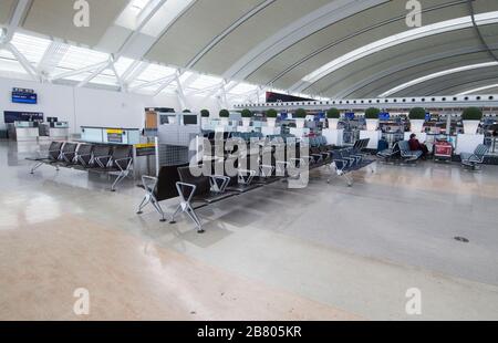 Toronto, Canada. 18th Mar, 2020. A traveller sits at Terminal 1 departure hall of Pearson International Airport in Toronto, Canada, March 18, 2020. Canadian Prime Minister Justin Trudeau announced that the Canada-U.S. border will close to all non-essential travel, but shipments, trade and commerce will not be affected by the new restriction at the Canada-U.S. border. Credit: Zou Zheng/Xinhua/Alamy Live News Stock Photo