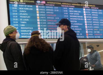 Toronto, Canada. 18th Mar, 2020. Cancelled flight information is seen on a screen at Terminal 1 passenger pickup area of Pearson International Airport in Toronto, Canada, March 18, 2020. Canadian Prime Minister Justin Trudeau announced that the Canada-U.S. border will close to all non-essential travel, but shipments, trade and commerce will not be affected by the new restriction at the Canada-U.S. border. Credit: Zou Zheng/Xinhua/Alamy Live News Stock Photo