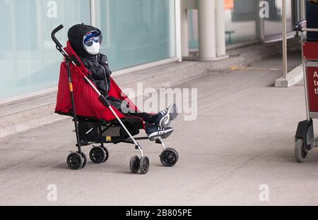 Toronto, Canada. 18th Mar, 2020. A child wearing a face mask is seen outside Terminal 3 of Pearson International Airport in Toronto, Canada, March 18, 2020. Canadian Prime Minister Justin Trudeau announced that the Canada-U.S. border will close to all non-essential travel, but shipments, trade and commerce will not be affected by the new restriction at the Canada-U.S. border. Credit: Zou Zheng/Xinhua/Alamy Live News Stock Photo