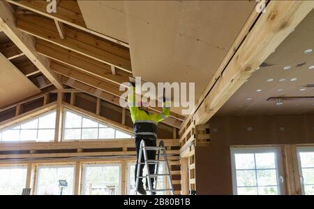 Construction worker thermally insulating eco wooden frame house Stock Photo