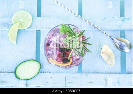 Top view of berries mojito cocktail on blue wood bar counter - Tropical, drinks, party and concept - Focus on glass Stock Photo