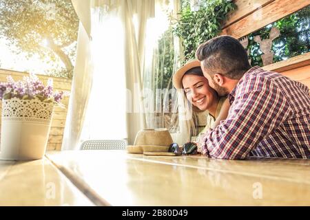 Young couple flirting at the first date at bar cafe table - Boyfriend and girlfriend enjoying time together in summer vacation - Travel and love conce Stock Photo