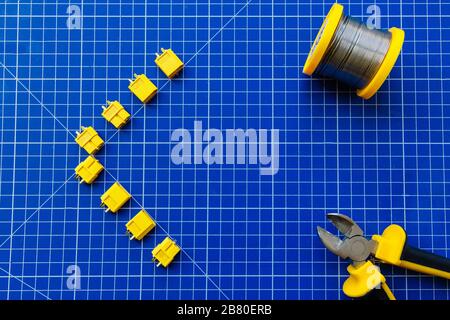 Blue rug for cutting. The connectors XT-60 are laid out on the mat. In one corner lies a solder coil. Stock Photo