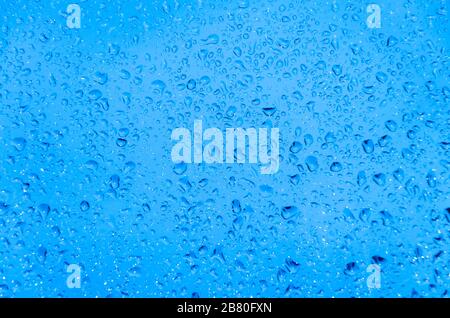 Rain drops on the window surface with blue cold light Stock Photo