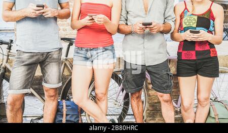 Group of students watching smart mobile phones in university break - Young people, addiction to new technology trends - Alienation moment for new gene Stock Photo