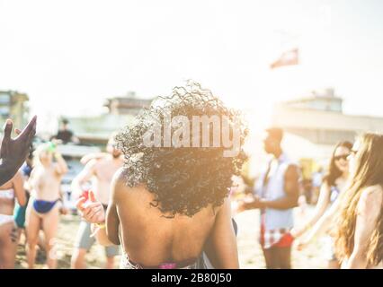 Young people dancing on beach party in summer time - Diverse culture friends having fun outdoor - Music and entertainment trends concept - Focus on bl Stock Photo
