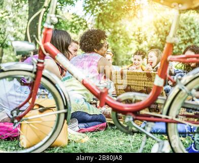 Diverse culture friends making picnic on city park outdoor - Young trendy people eating dinner in backyard outside - Focus on african hair girl - Yout Stock Photo