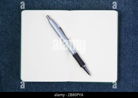 Ballpoint pen on notebook. On a blue background. Stock Photo