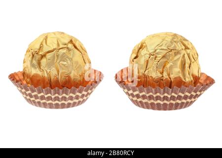 Two chocolate candies wrapped in gold. On a white background. Stock Photo