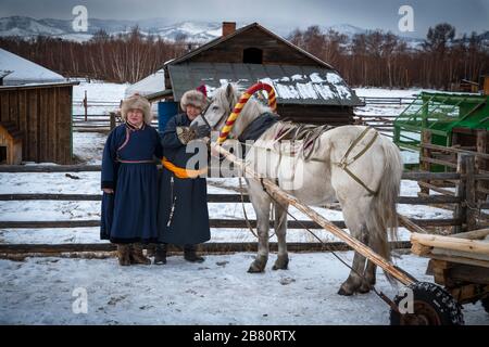 Naryn-Atsagat zone, near Oulan Oude (ulan ude), Siberia, Russia - Mars 09, 2020 : Couple of Buryats  in traditional costumes with their horse. Stock Photo