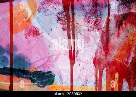 Colorful surface texture with splashes of paint and with paint that runs down on a metallic surface structure. For abstract backgrounds. Germany Stock Photo