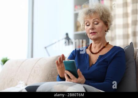 Concentrated lady typing on smartphone Stock Photo