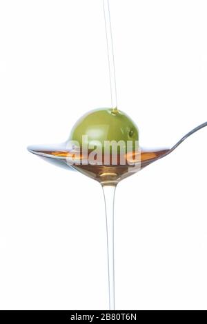 Olive on the spoon, pouring with oil. Stock Photo