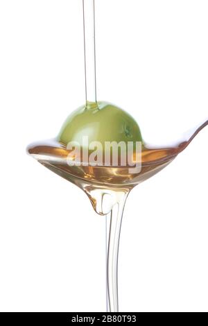 Olive on a spoon, spraying with oil. Stock Photo