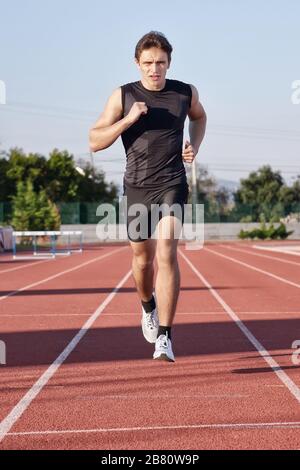 A young man run a hundred meters on the treadmill. Stock Photo