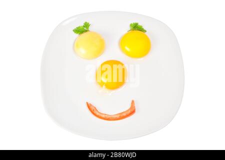 Raw eggs and tomatoes in a bowl in the shape of the face. Stock Photo