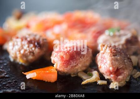 Frying meatballs with vegetables on grill, Morocco Stock Photo