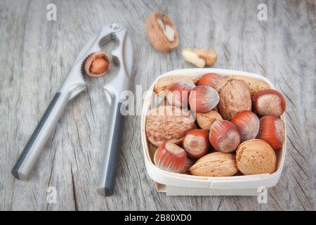 Nutcracker and a hazelnut with a basket of various nuts. Stock Photo