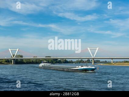 Dusseldorf, Rhineland, Germany, 09/15/2019 - ship passing Airport suspension bridge on a sunny day with blue sky. Stock Photo