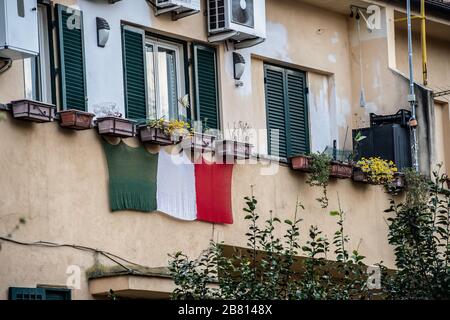 In Rome, Italian flags displayed on the balconies during the Coronavirus epidemic that has hit Italy heavily, Stock Photo