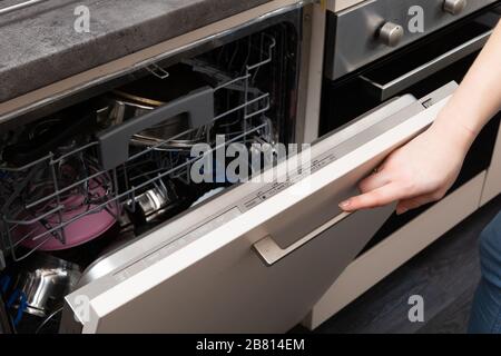 A dishwasher is a device that saves time, water and electricity and all dishes are thoroughly washed. Stock Photo