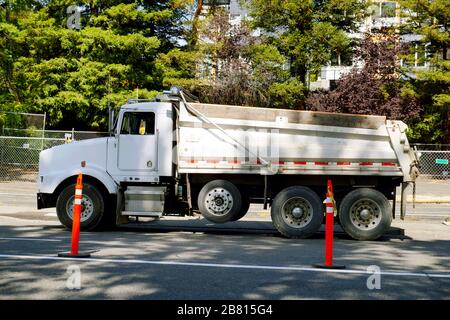 Big dump truck waiting to be unloaded. Road works in the city. Stock Photo