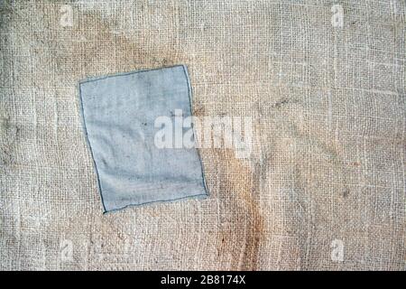 Aged vintage and weathered cloth background texture with patch. Old damaged brown rough texture Stock Photo