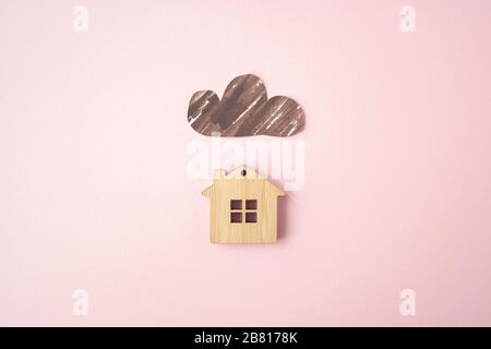 Paper dark cloud above the wooden house. Bad times, mortgage, no money concept. Flat lay. Top view Stock Photo