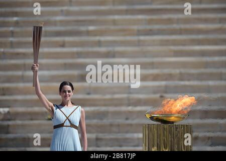 Athens, Greece. 19th Mar, 2020. Greek actress Xanthi Georgiou who was playing the role of an ancient Greek High Priestess, holds the torch to be delivered to Japan at the Panathenaic Stadium, in Athens, Greece, on March 19, 2020. Credit: Aris Messinis-pool photo/Xinhua/Alamy Live News Stock Photo