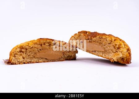 A cut cookie cake with peanut butter and caramel on white background with copy space - angled view Stock Photo