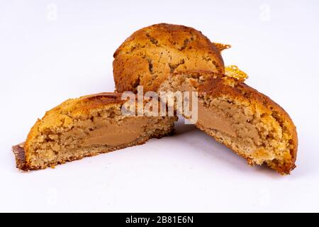 A cut cookie cake with peanut butter and caramel on white background with copy space - angled view Stock Photo