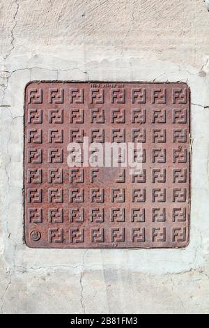 vintage and old rusted sewer cover in the street Stock Photo