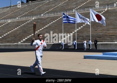 Athens, Greece. 19th Mar, 2020. Greek Olympic medalist in artistic gymnastics Eleftherios Petrounias holds the Tokyo Olympic Flame at the Panathenaic stadium, in Athens, Greece, on March 19, 2020. Credit: Aris Messinis-pool photo/Xinhua/Alamy Live News Stock Photo