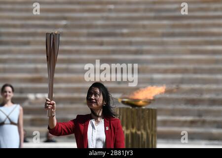 Athens, Greece. 19th Mar, 2020. Naoko Imoto, an Olympian in swimming at the Olympic Games of Atlanta 1996, holds a torch with the Tokyo Olympic Flame at the Panathenaic stadium, in Athens, Greece, on March 19, 2020. Credit: Aris Messinis-pool photo/Xinhua/Alamy Live News Stock Photo