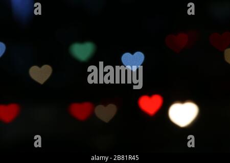 Valentines Colorful heart-shaped on black background lighting bokeh for decoration at night backdrop wallpaper blurred valentine, Love Pictures backgr Stock Photo