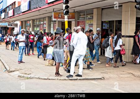 Long line of people queuing to get into the store. Queuing has become the norm in Harare. Stock Photo