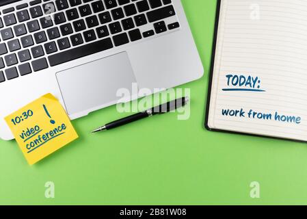 working from home and home office concept, laptop and notepad on desk with video conference reminder Stock Photo