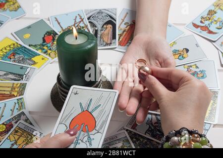 Bangkok, Thailand, March.15.20.A Gypsy woman guesses a love match using wedding rings and fortune-telling cards by candlelight.Fortune telling with we Stock Photo