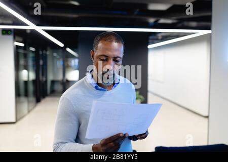 African American man reading papers in office Stock Photo