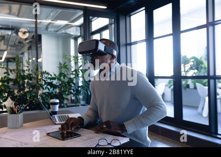 African American man using virtual reality in office Stock Photo