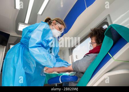 Campobasso,Molise Region,Italy:A nurse draws blood from a donor woman in an Avis camper outside the Cardarelli hospital in Campobasso, prepared for th Stock Photo