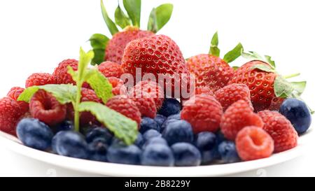 Different fresh summer berries (raspberry, blackberry, strawberry)  with leaf  on the white plate isolated on white background Stock Photo