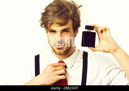 Bearded man, short beard. Caucasian stylish man posing with perfume in shirt and suspenders in studio isolated on white background Stock Photo