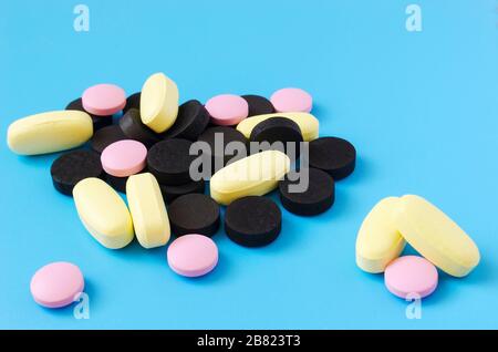 colored pills on a blue background2 Stock Photo