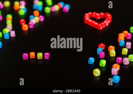 love word folded with colorful cubes with letters and a heart on a black background Stock Photo